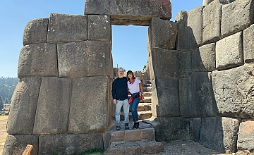 Sacsayhuaman, Cusco: entrada de piedra con viajeros en el sitio arqueologico