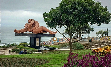 Escultura ‘El Beso’ en el Parque del Amor, Miraflores, con jardines y vista al océano Pacífico